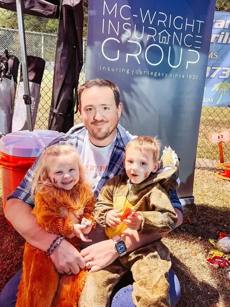 Brandon with kids in Halloween costumes at the Mc-Wright booth