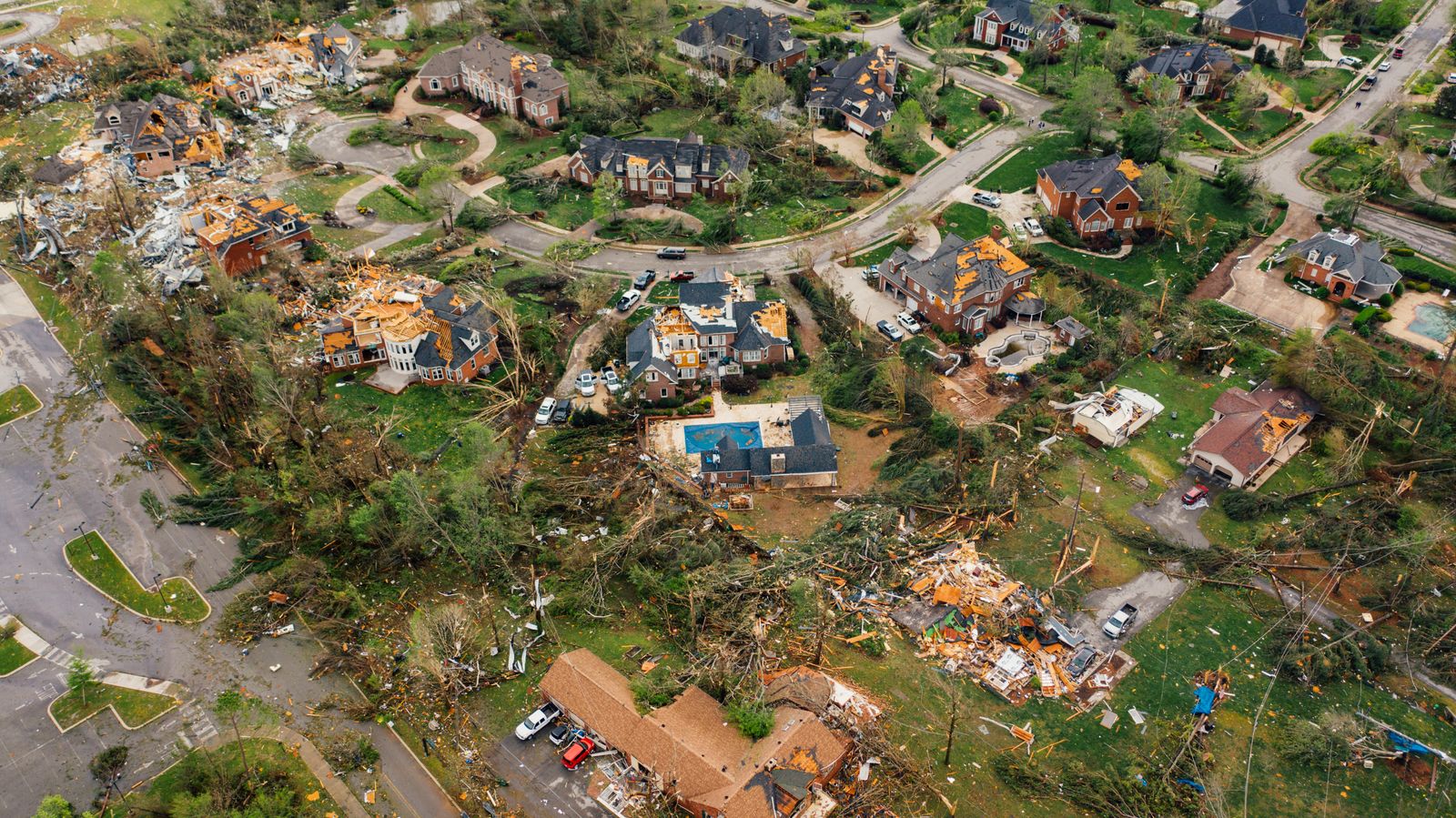 Houses damaged by a severe thunderstorm under a dark sky