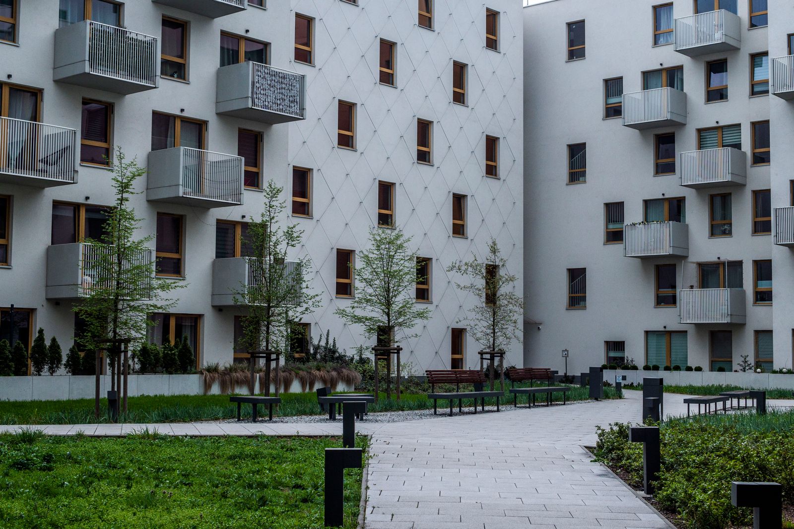 A modern apartment building with a green courtyard