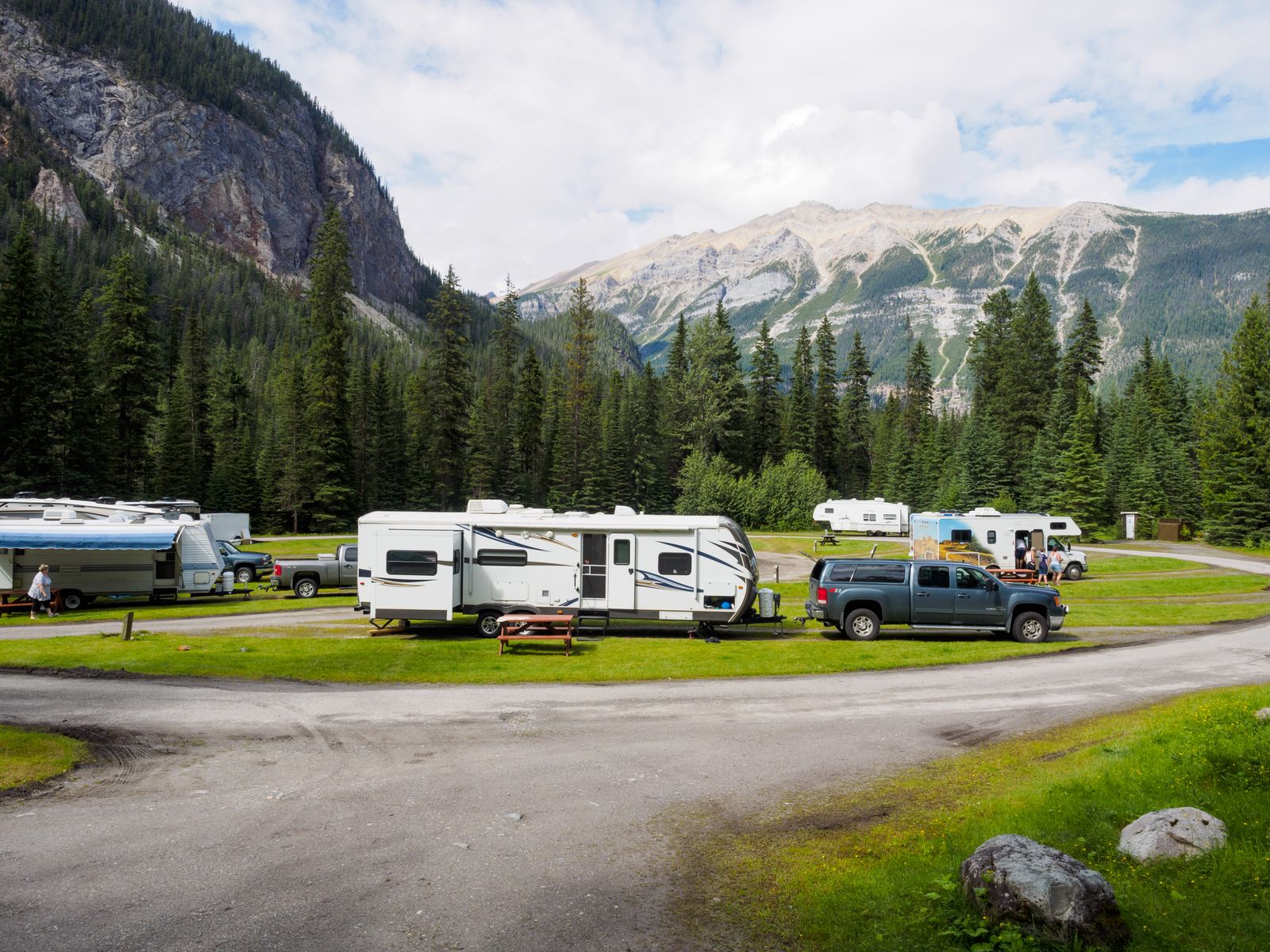 RVs and trailers parked at a mountain campsite