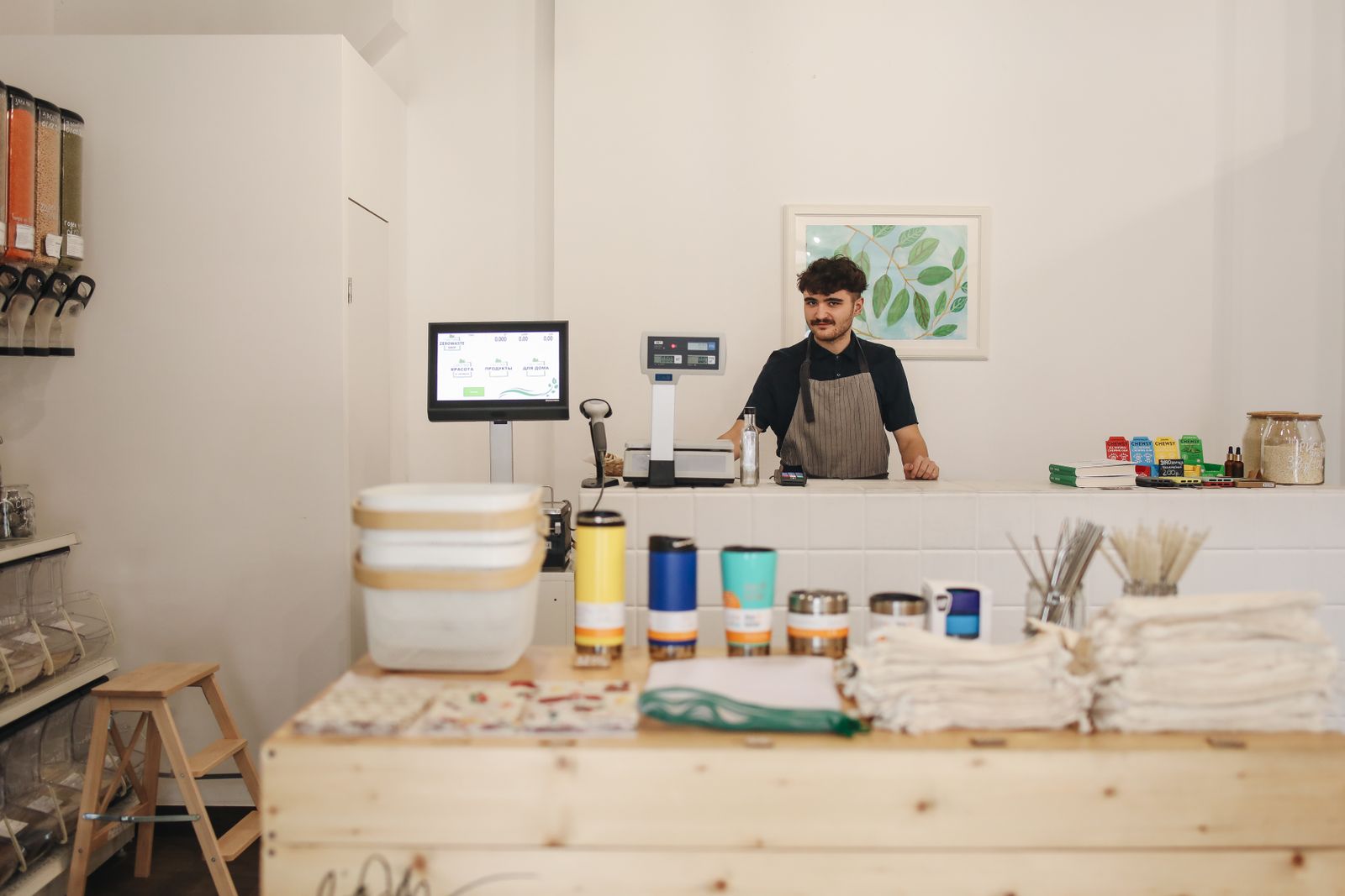 A shop owner standing behind his counter